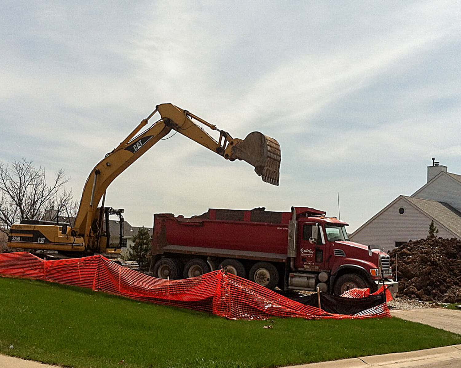 Lemel Homes Teardown, Rebuild, & Infill - Fire Rebuild - excavator dumping a load into a dump truck