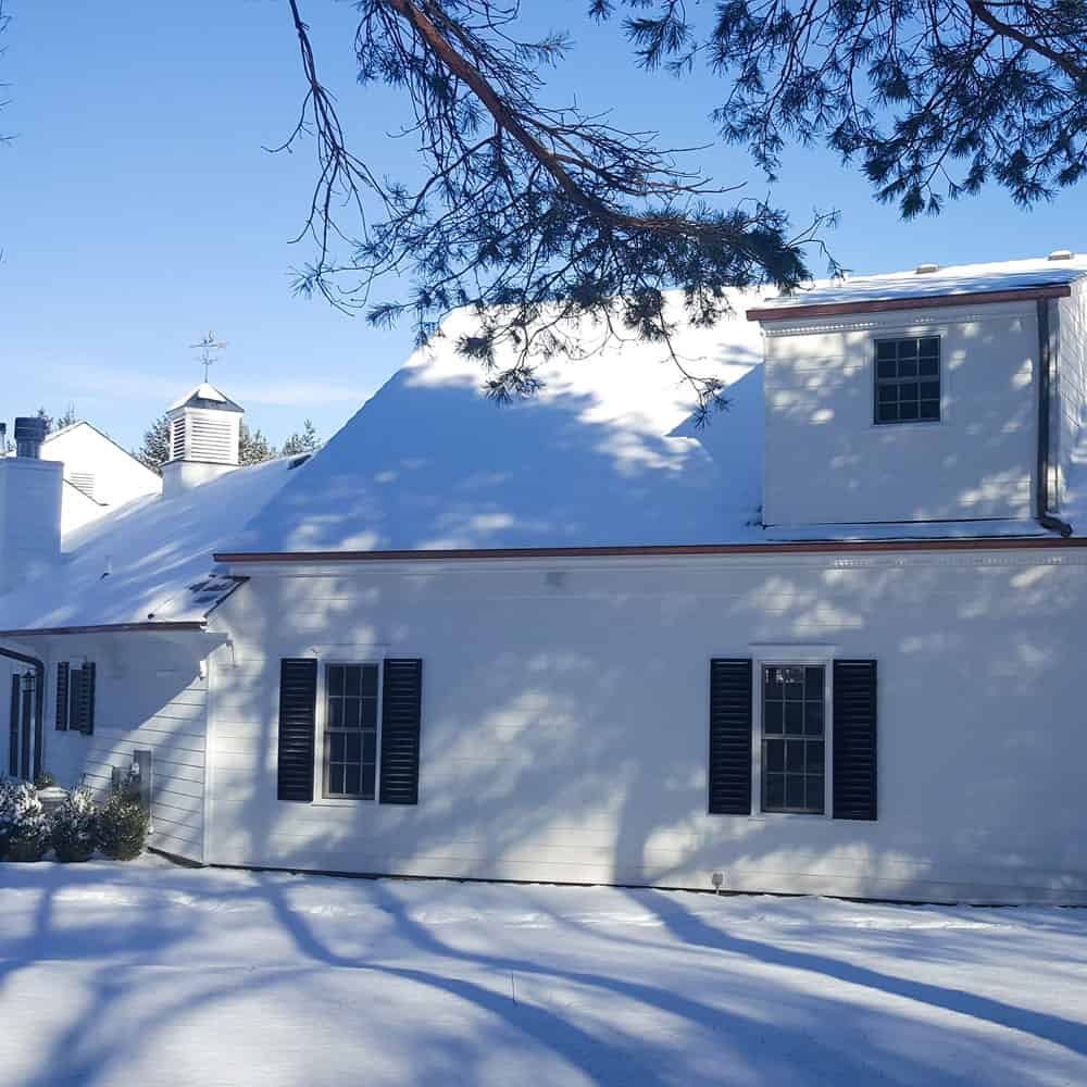 snow covered house with white siding